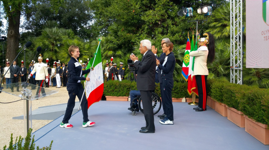 Bebe mentre riconsegna la bandiera tricolore al Presidente Mattarella
