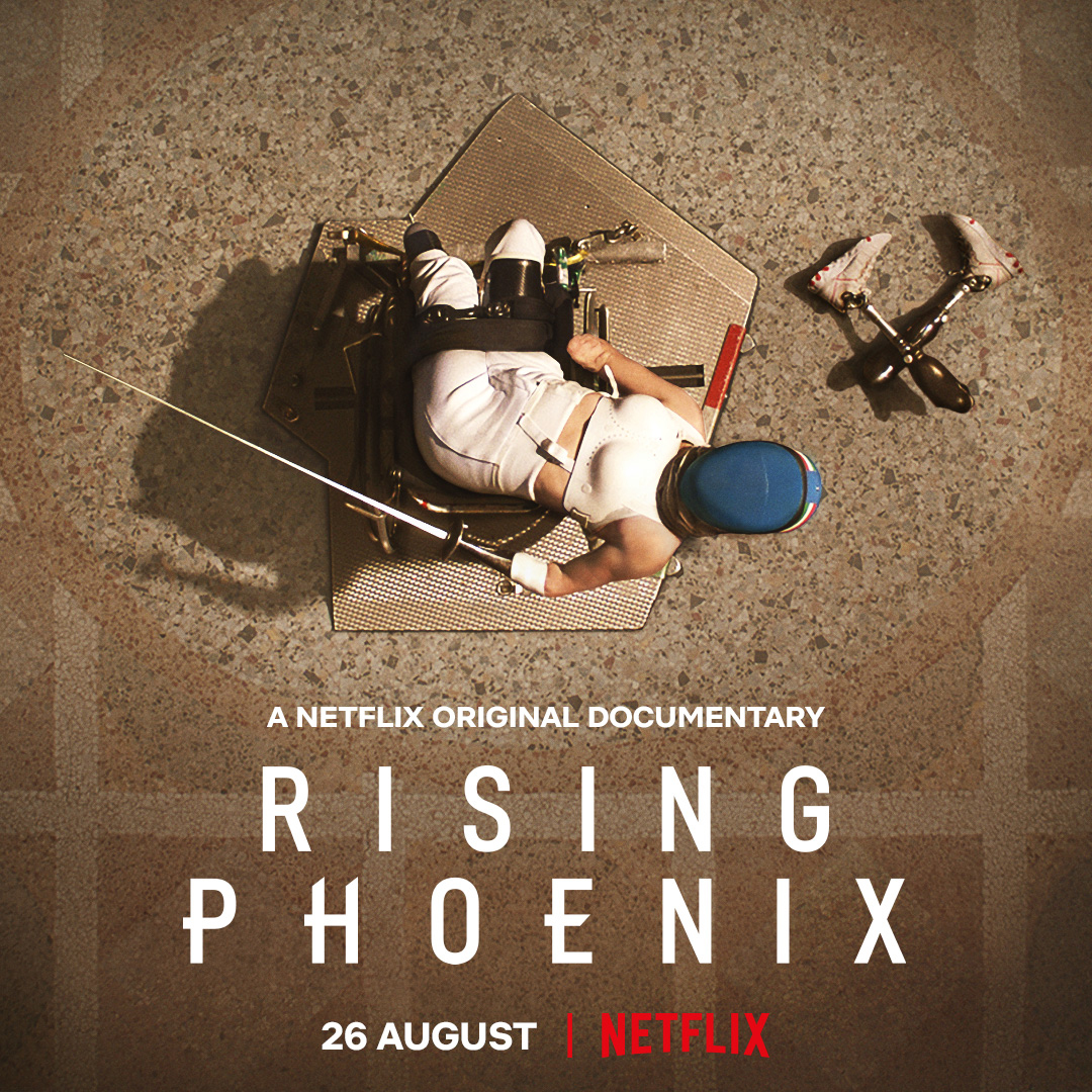 A Paralympic fencer who is light skinned, in her gear, sits in her wheelchair and looks up to the sky. Her prosthetic legs are on the ground. White text superimposed on the photo that reads "A Netflix Original Documentary Rising Phoenix 26 August Netflix